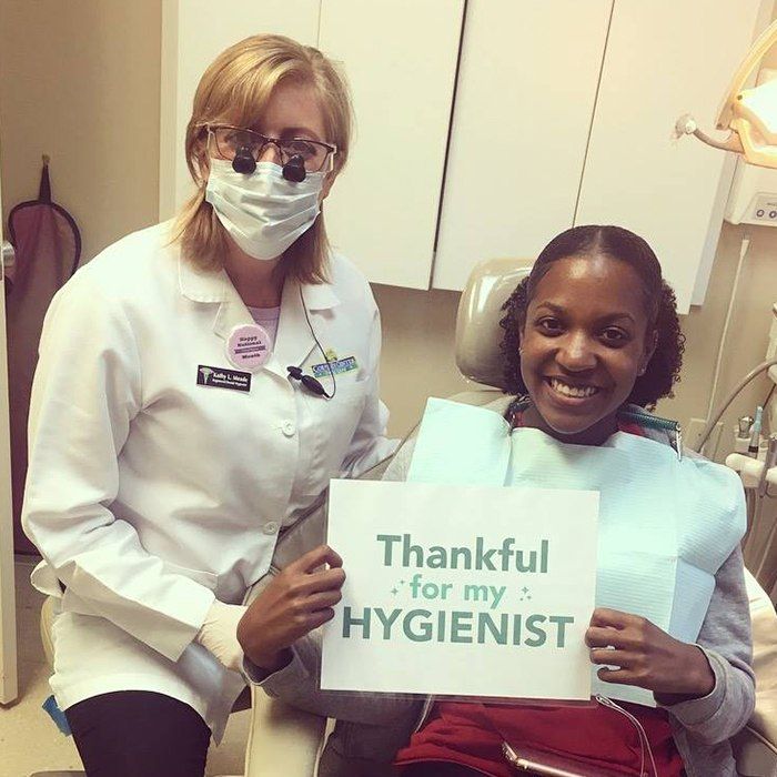 Smiling dentist and patient in dental exam room