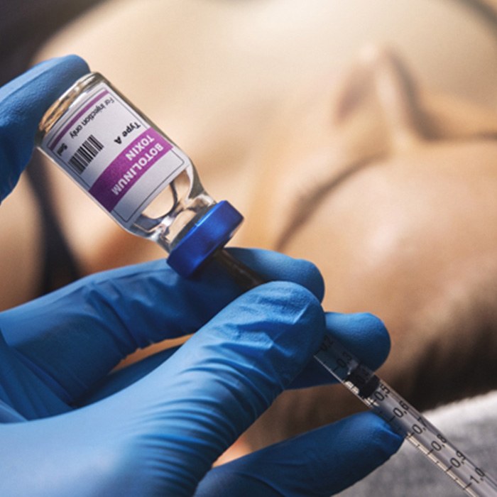 a syringe extracting BOTOX from a container