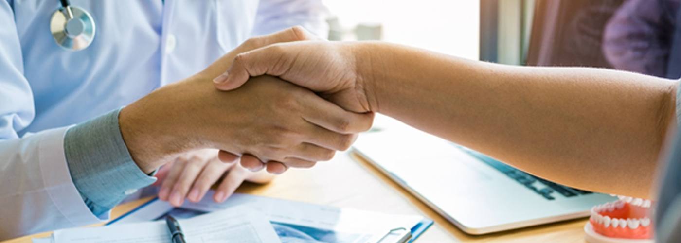 Patient and dentist shaking hands