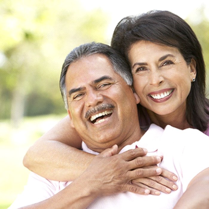 An older man and woman hugging and smiling