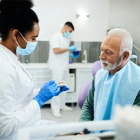 A dentist talking to her senior patient about dentures