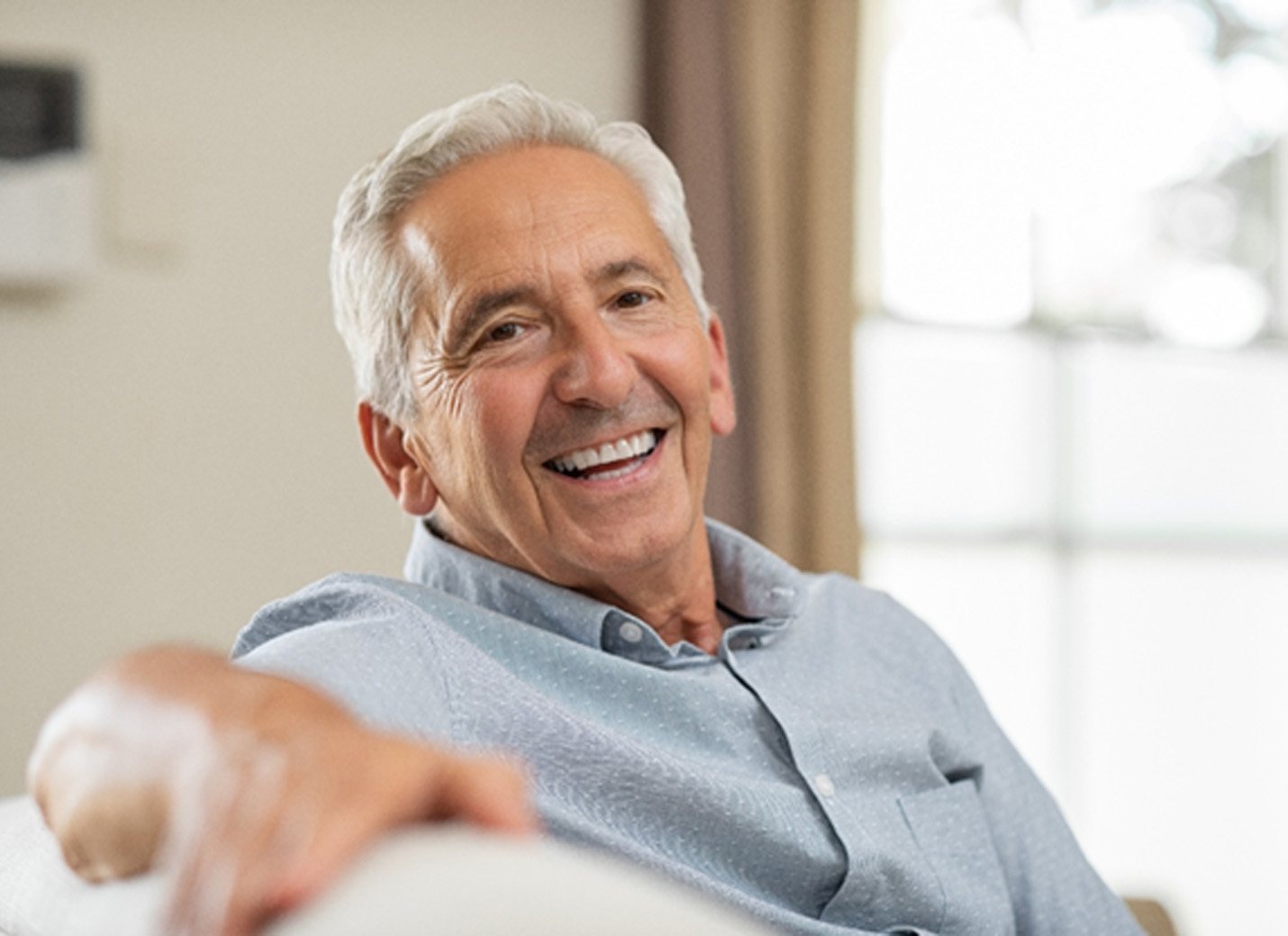 man smiling while sitting on couch 