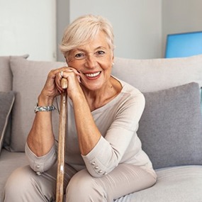 a woman smiling after receiving her dentures