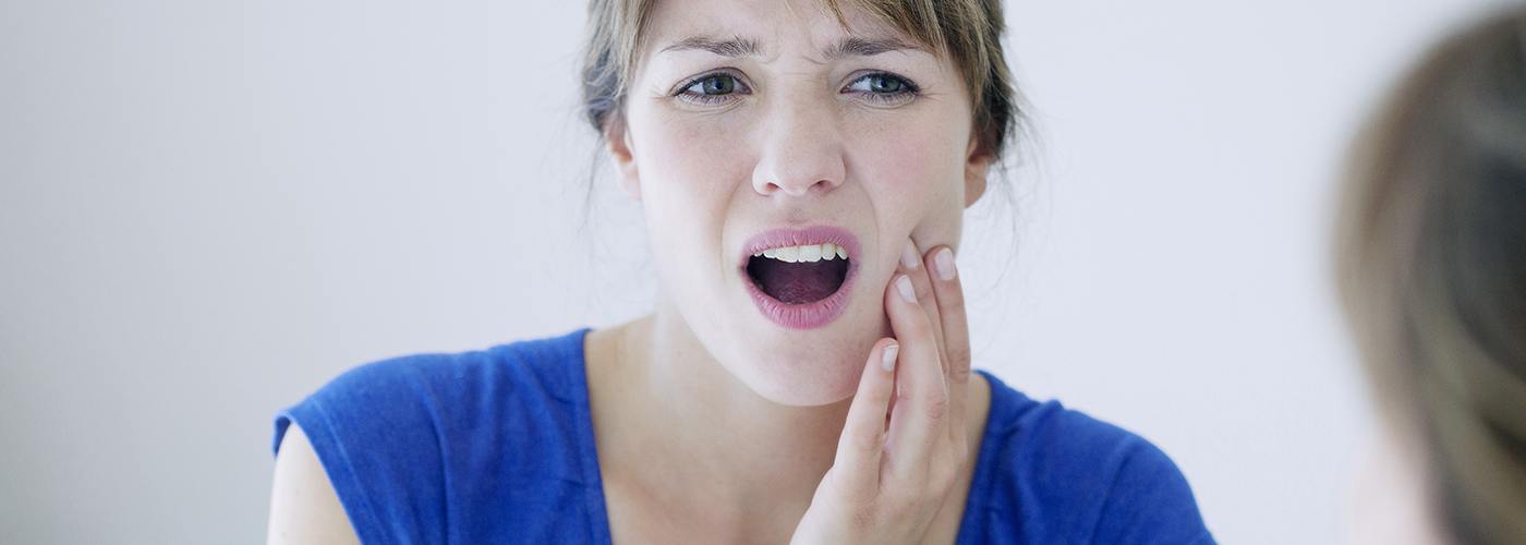 Woman in pain who needs emergency dentist in Lexington