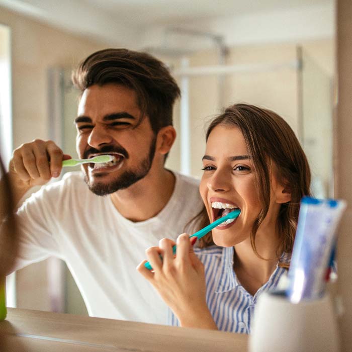 Couple brushing teeth to prevent dental emergencies in Lexington