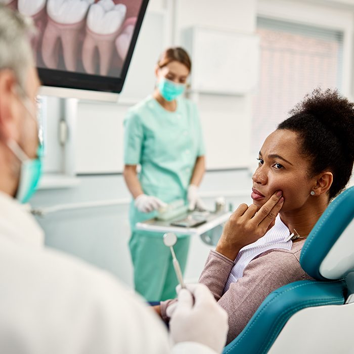 Woman with toothache talking to dentist