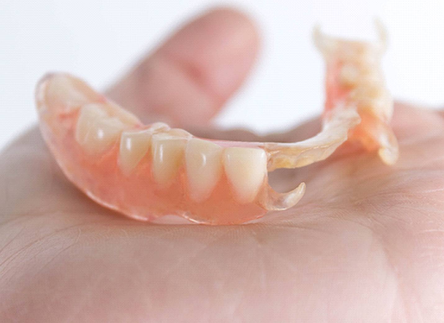 person holding partial dentures