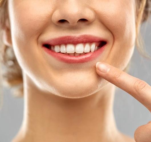 woman pointing to her smile