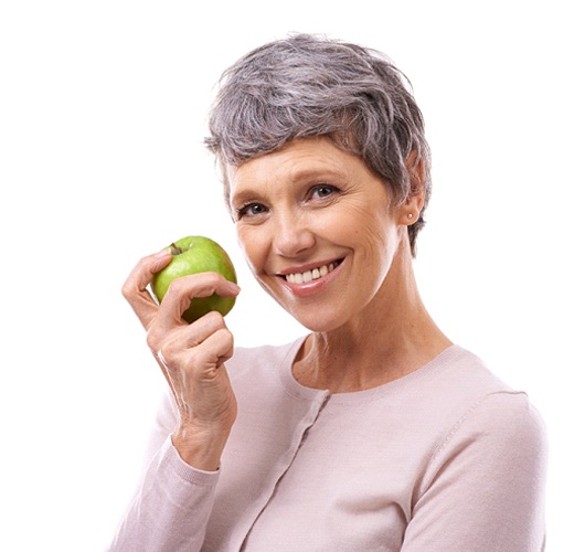 smiling woman holding a green apple