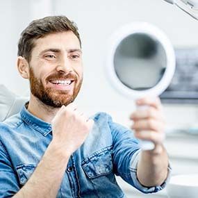 Young man admiring his new dental implants in Lexington