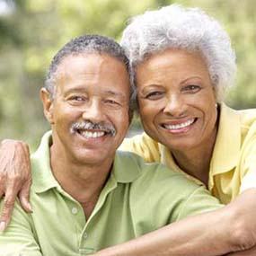 Healthy couple with dental implants in Lexington smiling outside