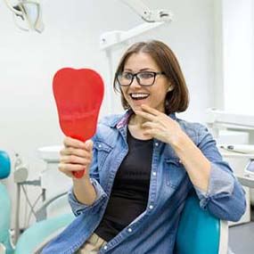 Young woman admiring her new dental implants in Lexington