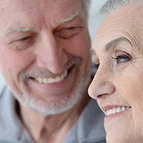 Smiling couple with beautiful smiles thanks to dental implants in Lexington