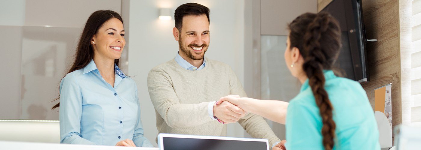 Man and woman at dental reception desk