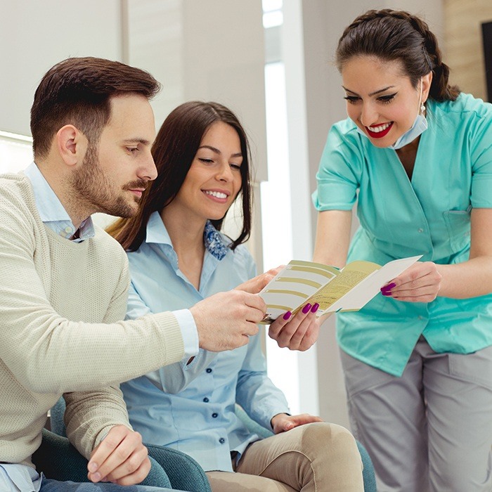 Man and woman talking to dental team member