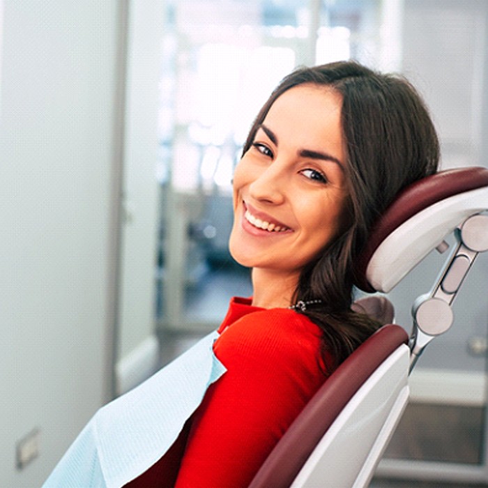 Smiling dental patient sitting in dental chair