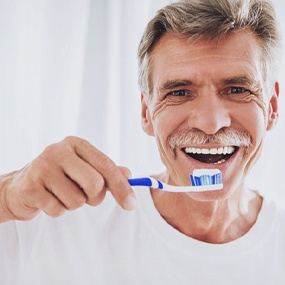 Man brushing his teeth to prevent dental emergencies in Lexington