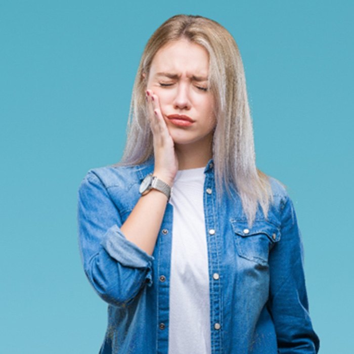 Woman holding her mouth and wincing