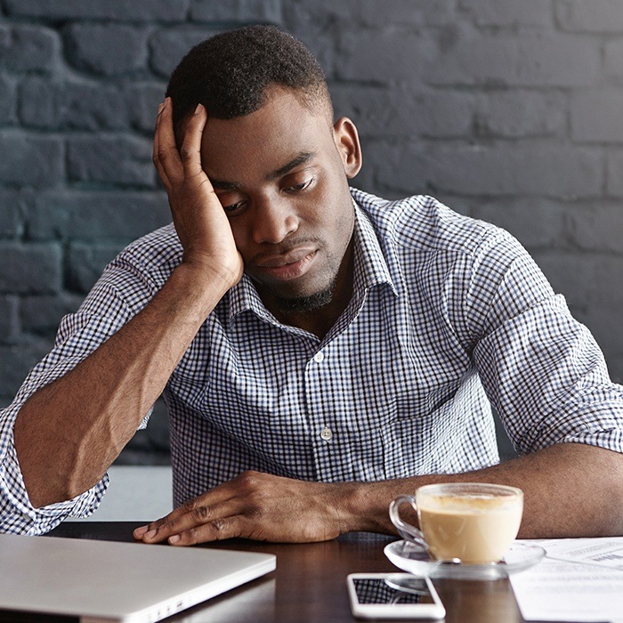 Tired man with head in hands