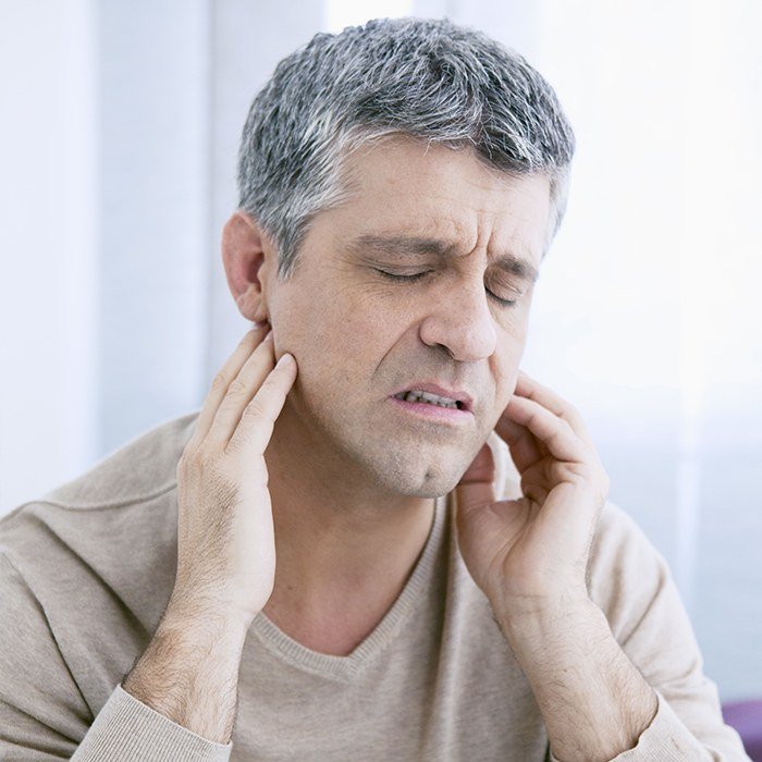 Man in pain holding jaws