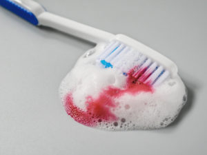 Toothbrush with toothpaste and blood mixed in sink