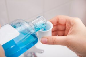 dentist in Lexington, KY pouring mouthwash into cup 