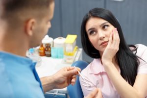 woman with a toothache talking to her emergency dentist in Lexington 