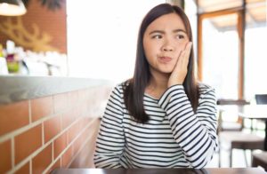 Woman wondering if dental insurance will cover her dental emergency