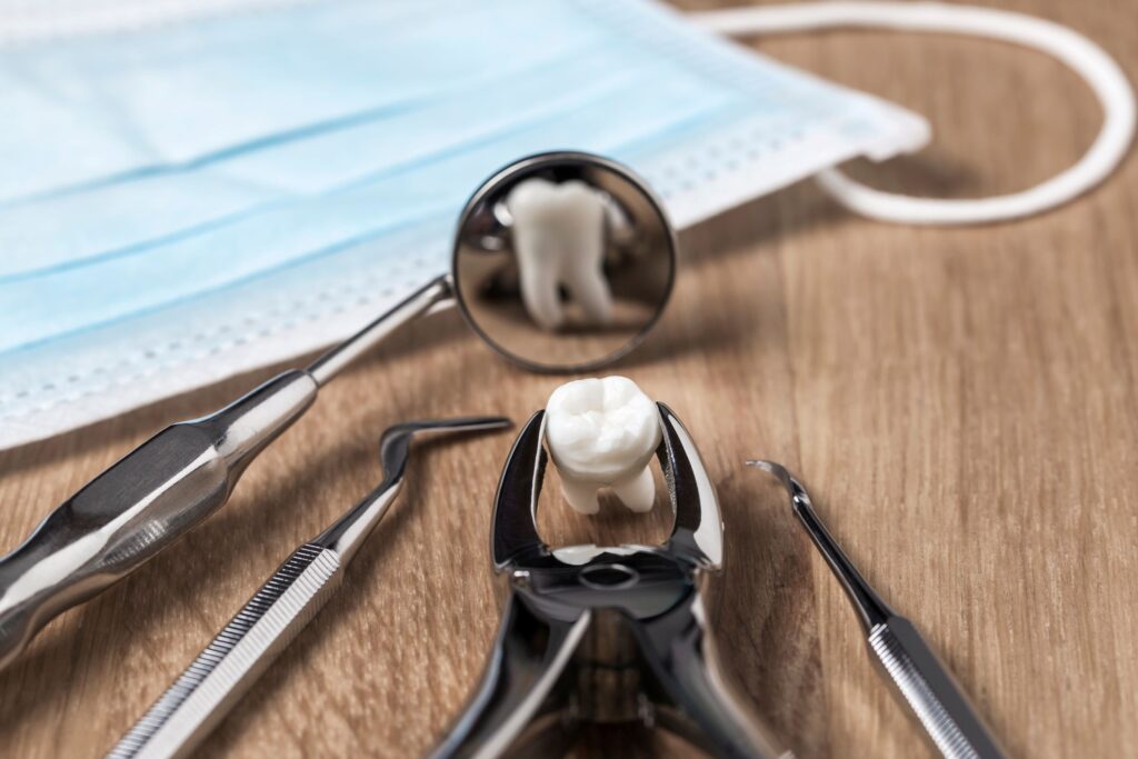 Extracted tooth next to dental instruments reflected in mirror